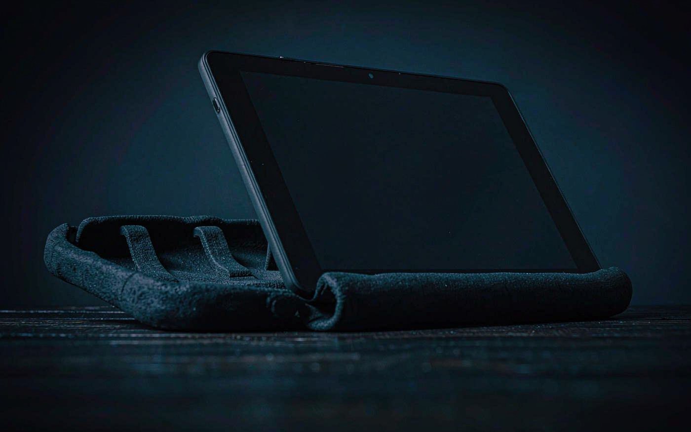A tablet standing in a thick foam protective case on a dark wooden table